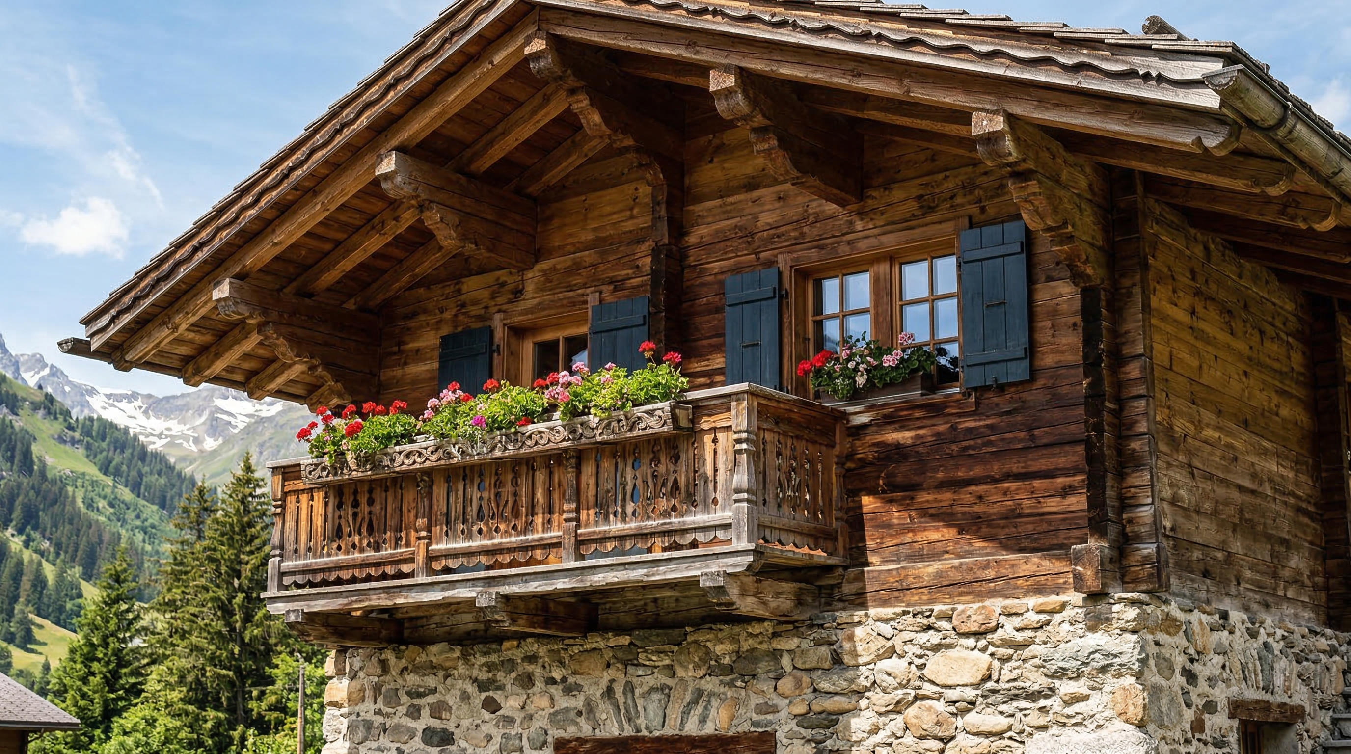 Традиционный альпийский шале — каменный цоколь, резной деревянный балкон с цветами, массивная крыша